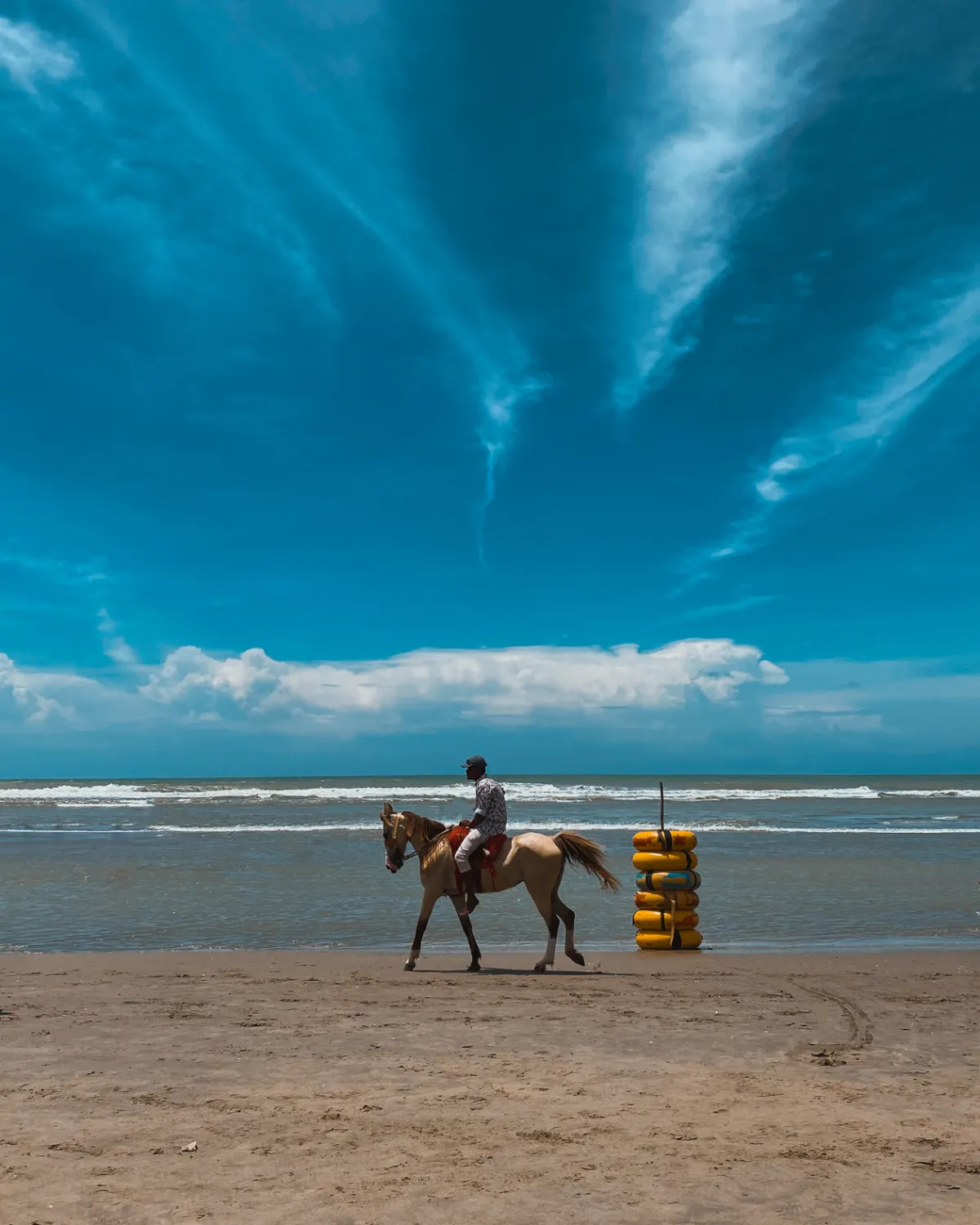 A horse rider galloping along the surf line at Cox's Bazar beach