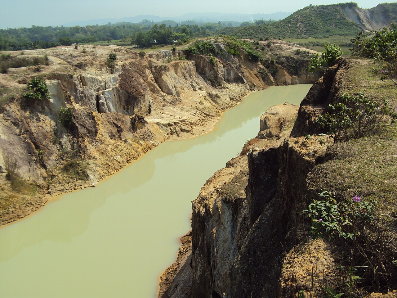 White china-clay cliffs above a golden river at Birishiri, Netrokona, Bangladesh